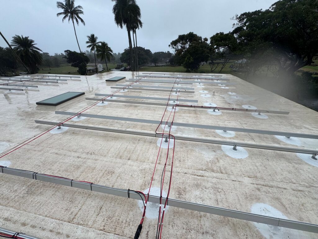 Solar mounting rails being installed on a flat commercial roof on Oʻahu